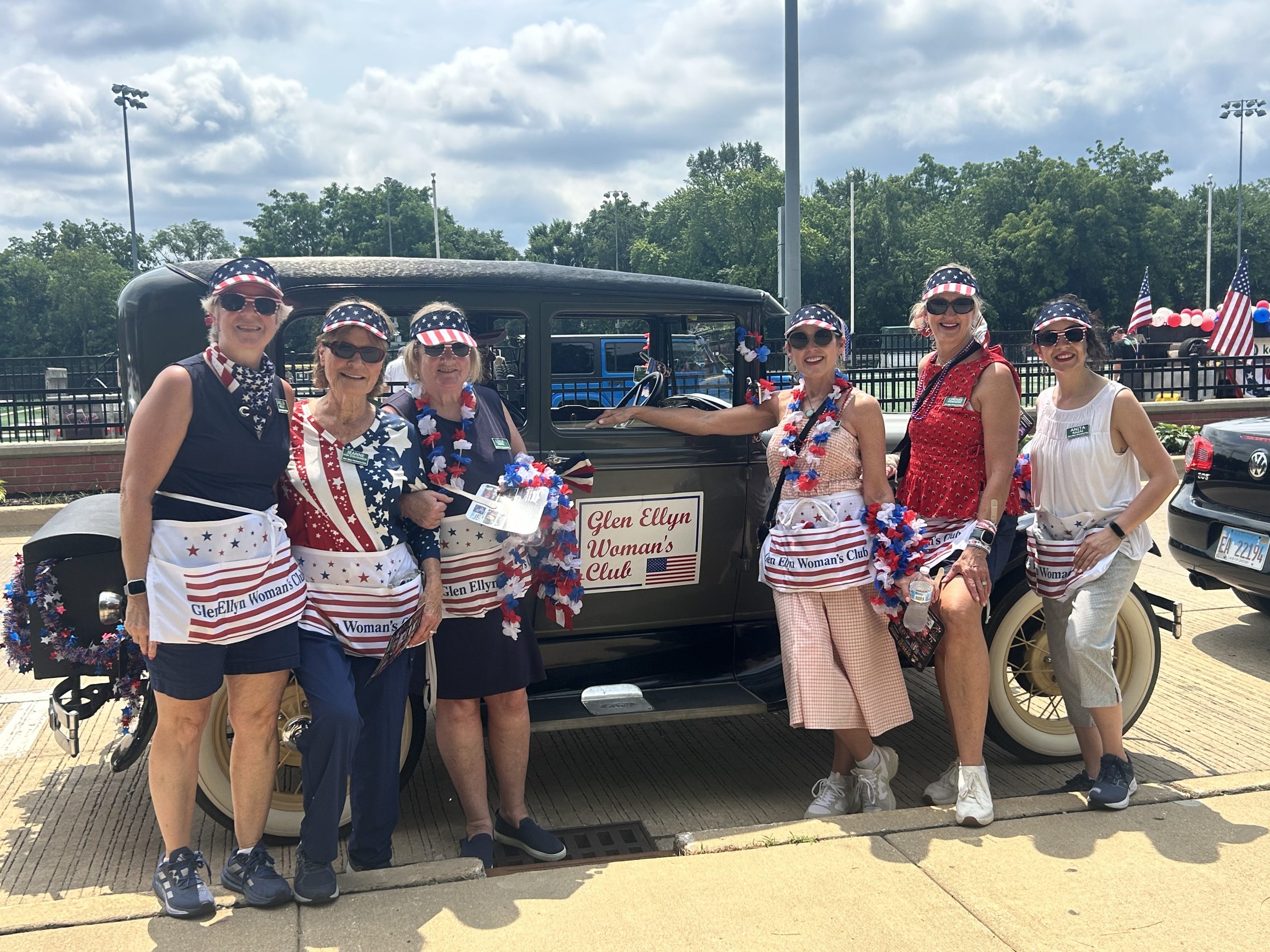 Women dressed for 4th of July by old Model A Ford car
